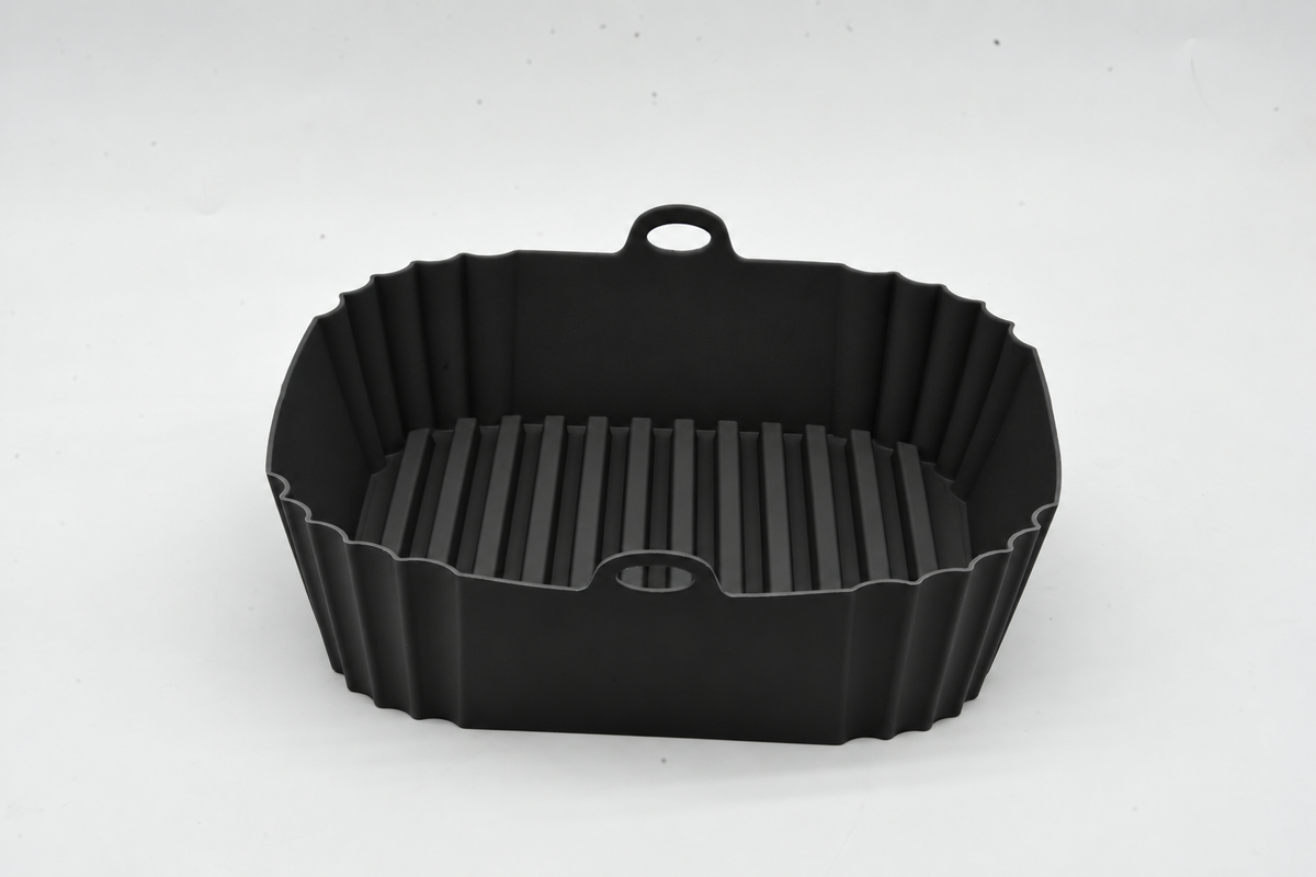 Front view of a black square silicone air fryer liner with ridges and lifting handles