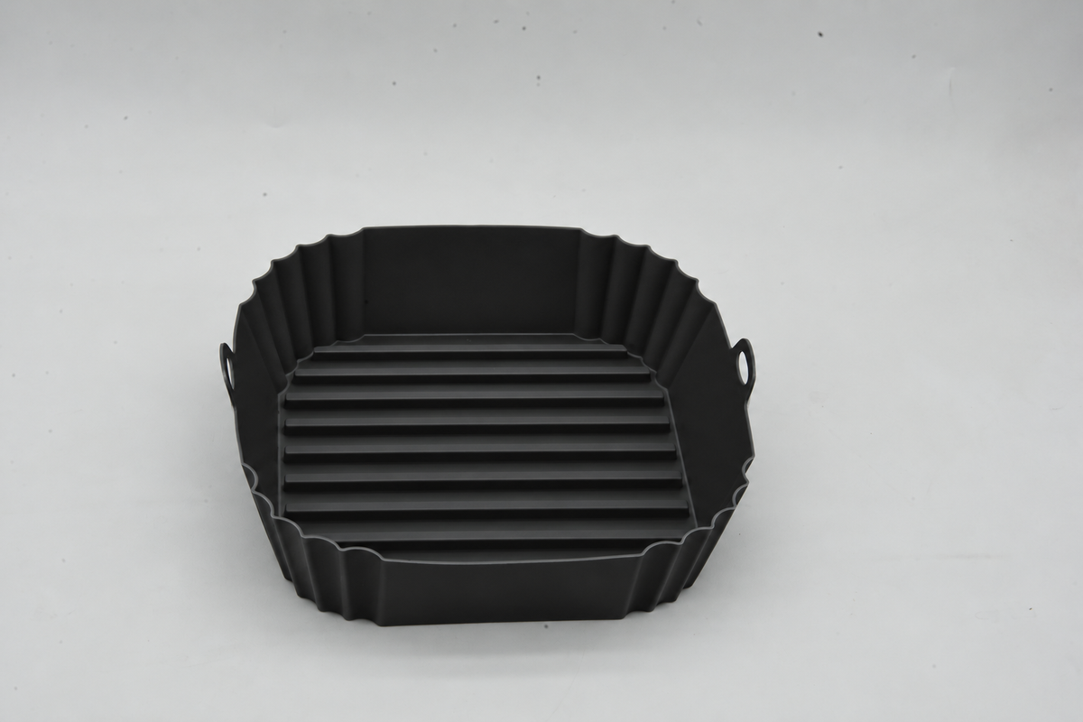 Top view of a black square silicone air fryer liner showing its raised base ridges