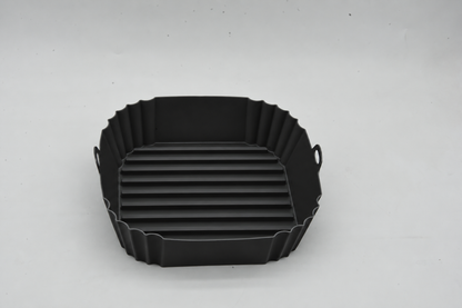 Top view of a black square silicone air fryer liner showing its raised base ridges
